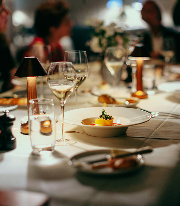 Fokus auf Desserteller im Restaurant Le Grand Bellevue Gstaad, um den Tisch sitzen Leute und essen.