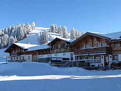 Verschneites Berghotel inmitten einer herrlichen Schneelandschaft.