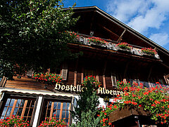 Exterior view of the Hotel Alpenrose. Chalet house with red geraniums.