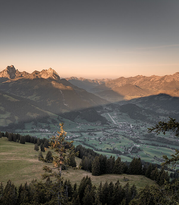 Sicht vom Hornberg auf das herbstliche und im Abendrot liegende Saanenland.