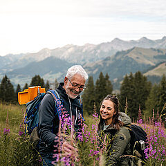 Une dame et un monsieur en train d'admirer la flore et la faune sur la montagne.