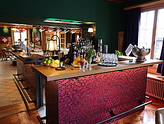 A bar in the middle and tables with seating in the background
