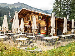 Bâtiment en bois avec ses tables et ses parasols.